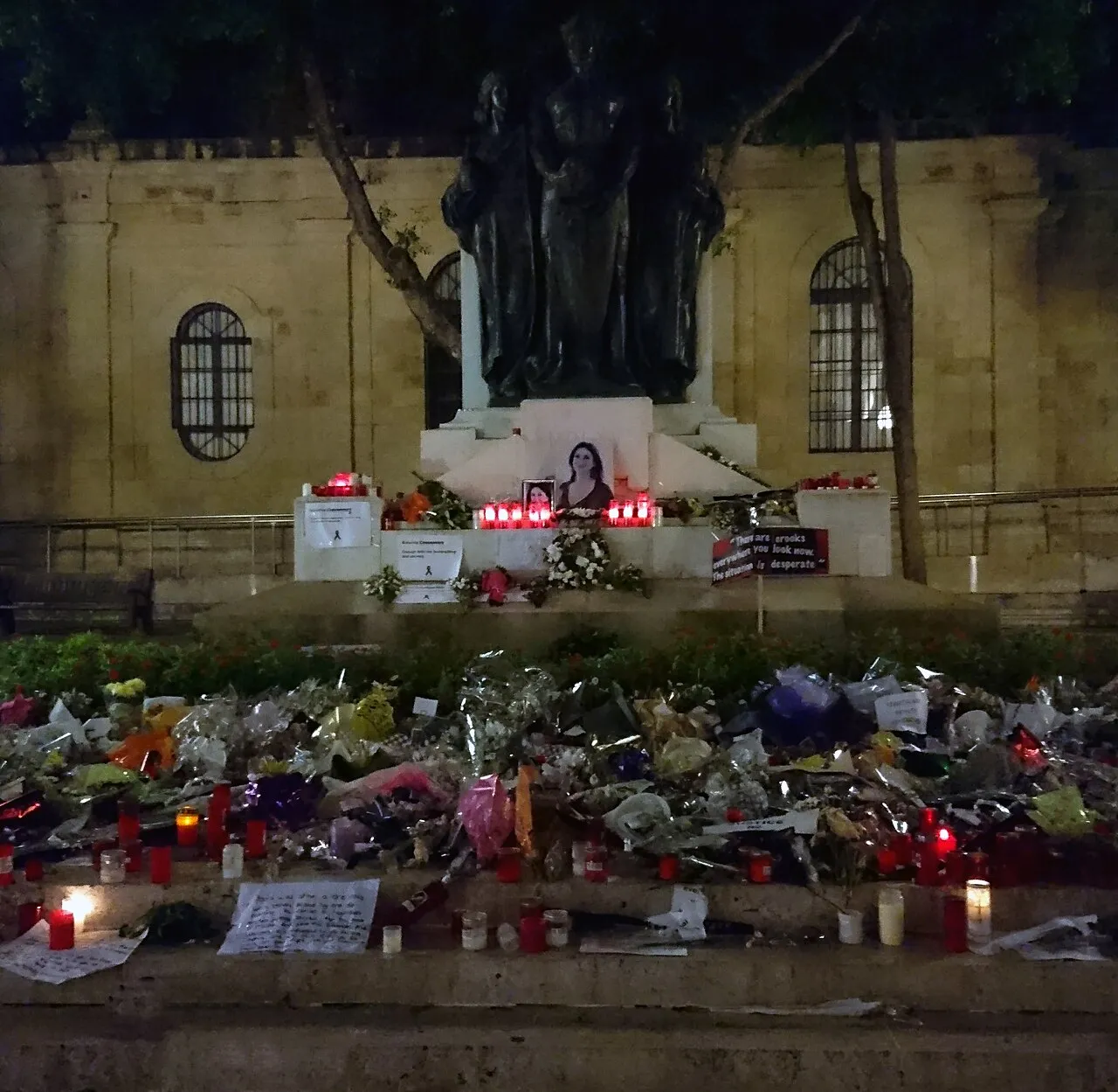 Bloemen, kaarsen en andere tributen bij het Great Siege Monument voor het gerechtsgebouw in Valletta, ter herdenking van Daphne Caruana Galizia