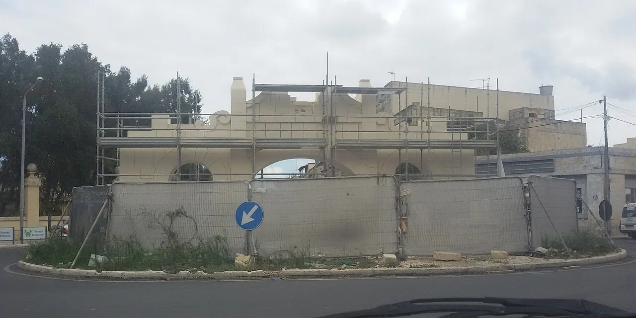 Een bouwplaats op Malta, met steigers rond een gebouw in aanbouw